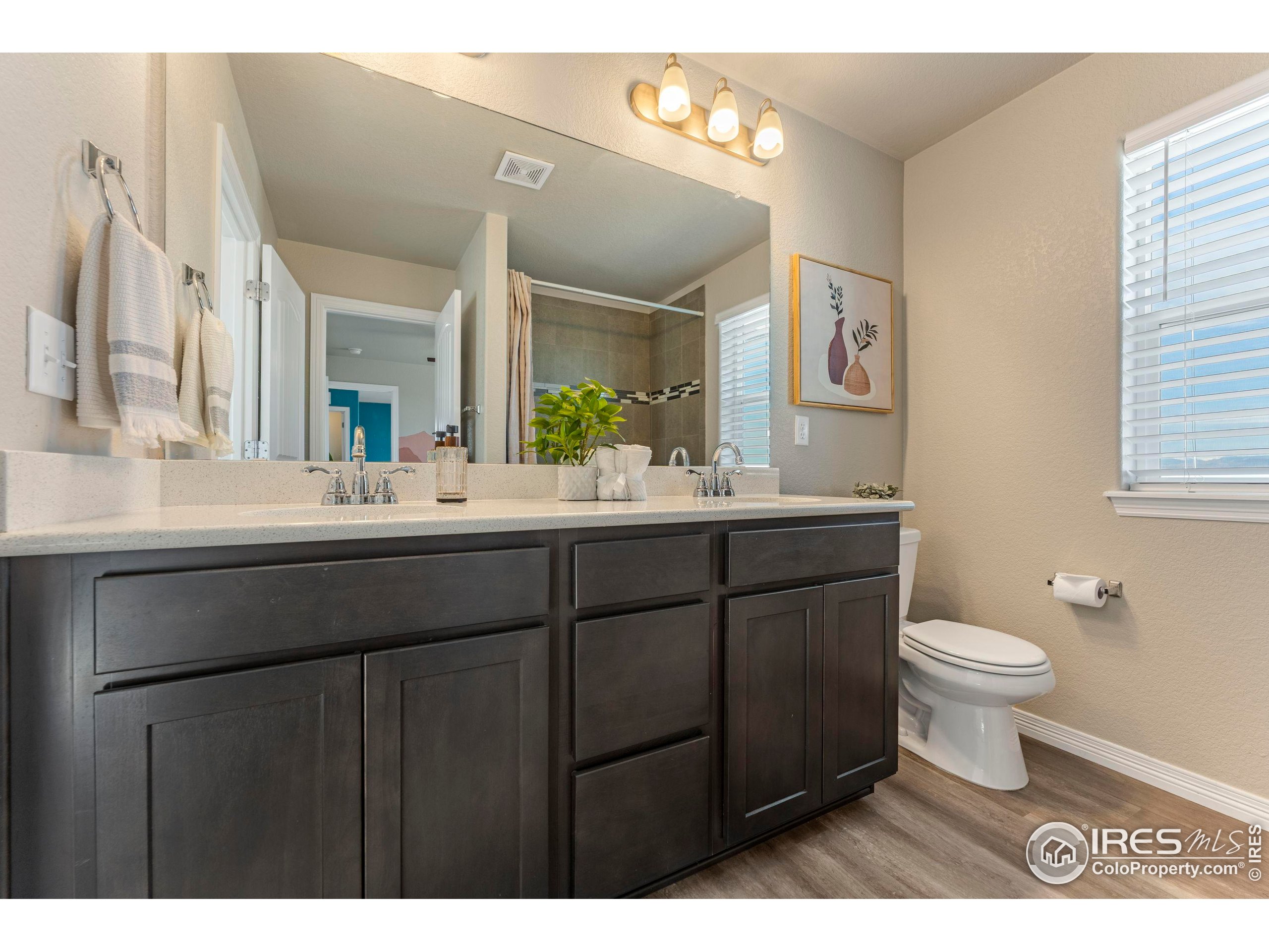 4527 Longmead Drive Windsor, CO 80550 - Photo 24 of 32 a bathroom with a double vanity sink toilet and a mirror