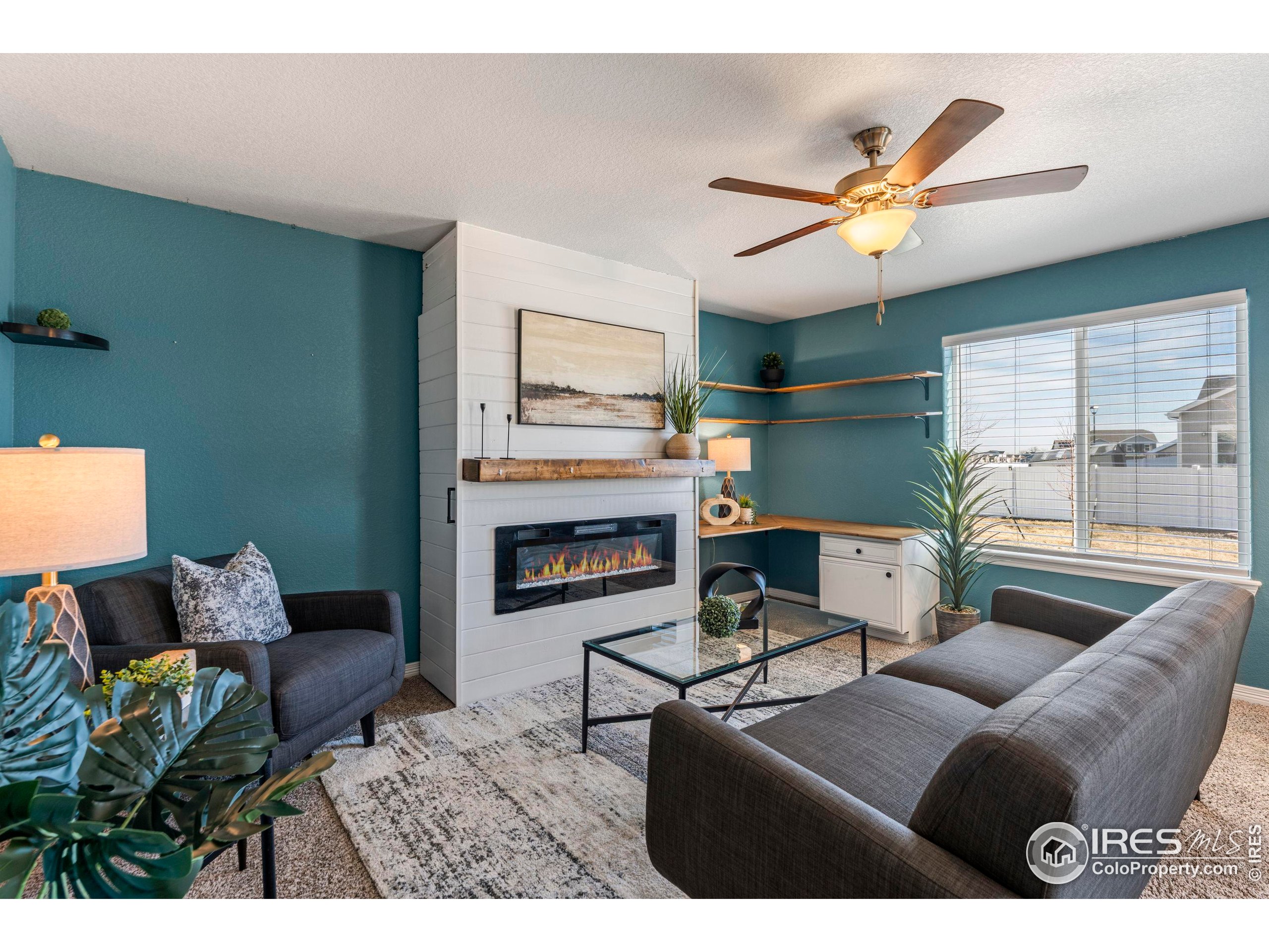 4527 Longmead Drive Windsor, CO 80550 - Photo 3 of 32 a living room with furniture and a fireplace