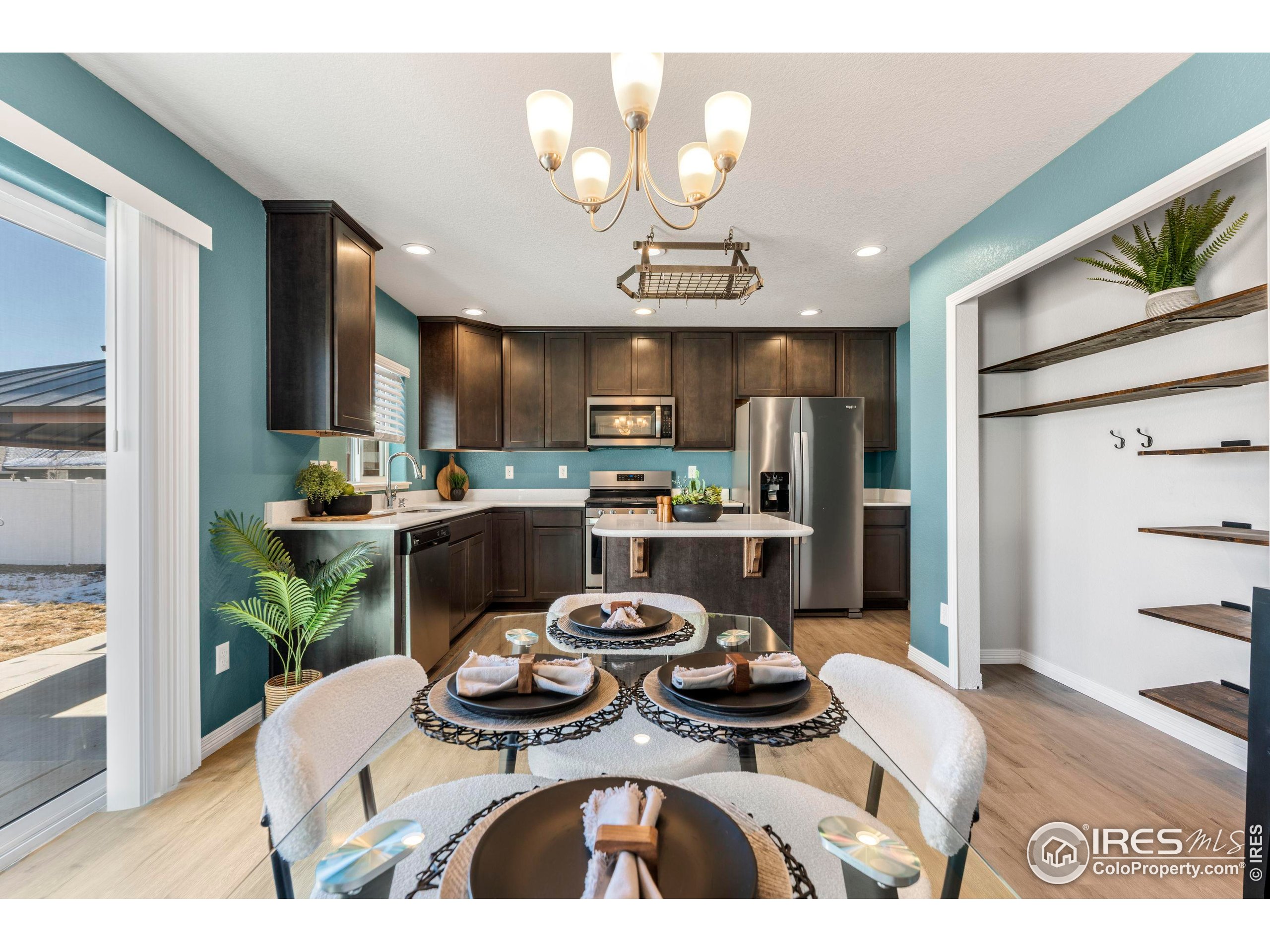 4527 Longmead Drive Windsor, CO 80550 - Photo 6 of 32 a kitchen with a refrigerator and a stove top oven