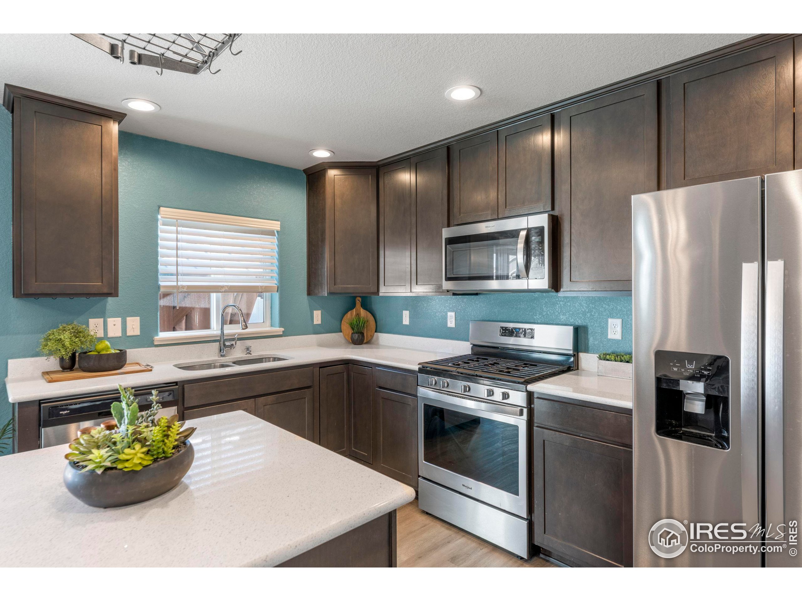4527 Longmead Drive Windsor, CO 80550 - Photo 10 of 32 a kitchen with a sink stainless steel appliances and cabinets