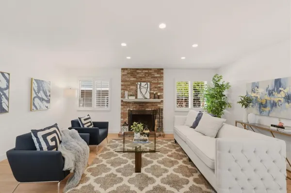 a living room with furniture potted plant and a table
