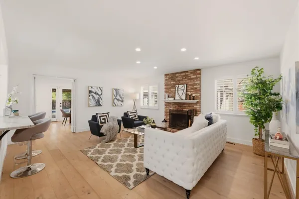 a living room with furniture a fireplace and a large mirror next to a window