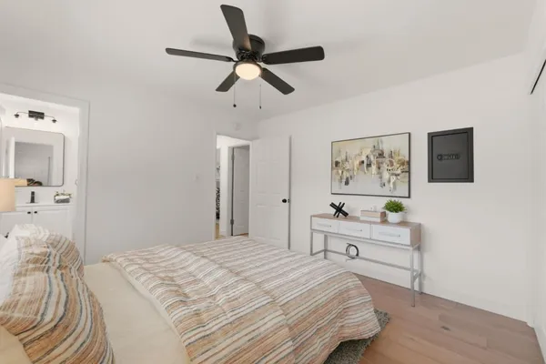 a bedroom with a large bed and a chandelier