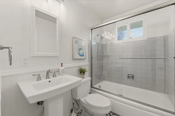 a closeup of a sink a mirror with potted plants on the wall