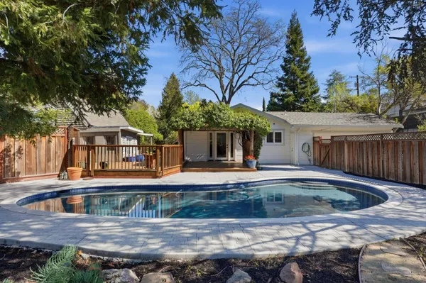 a view of a patio with table and chairs with wooden fence and floor