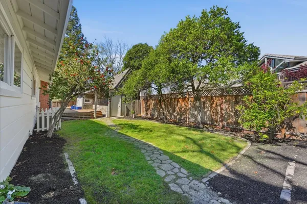 a front view of a house with a yard and green space