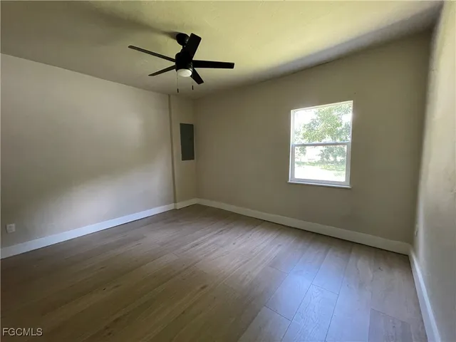 a living room with a fireplace and wooden floor