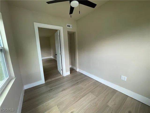 wooden floor fireplace and windows in an empty room