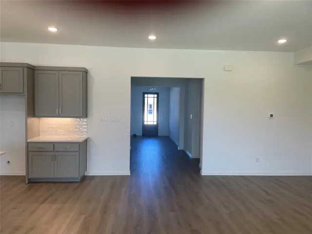 an empty room with wooden floor and mirror