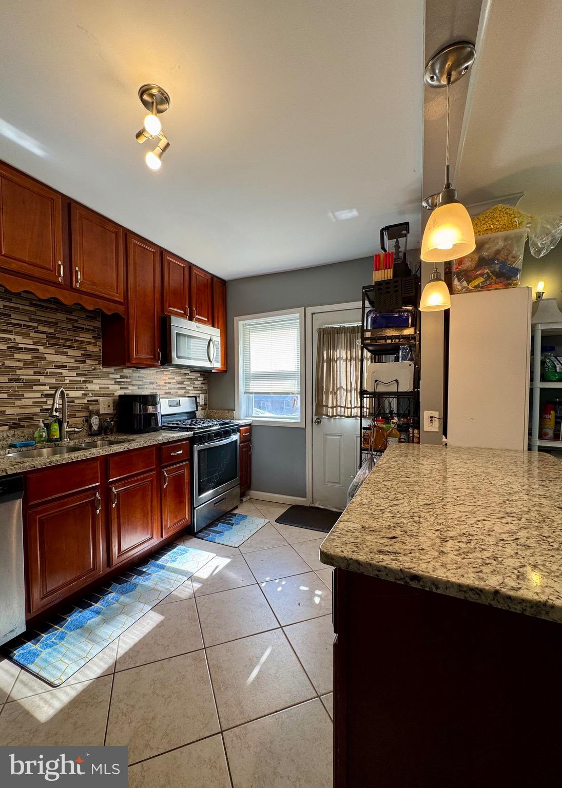 1519 Northgate Road Baltimore, MD 21218 - Photo 4 of 34 a kitchen with stainless steel appliances granite countertop wooden cabinets a stove top oven a sink and dishwasher
