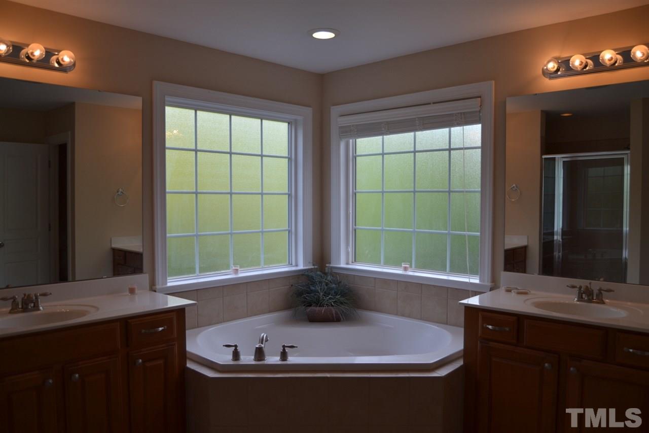 8425 Henderson Road Apex, NC 27539 - Photo 14 of 25 a bathroom with a tub a sink and a window