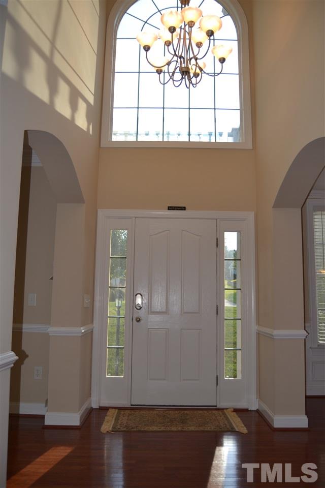 8425 Henderson Road Apex, NC 27539 - Photo 4 of 25 an empty room with wooden floor and windows