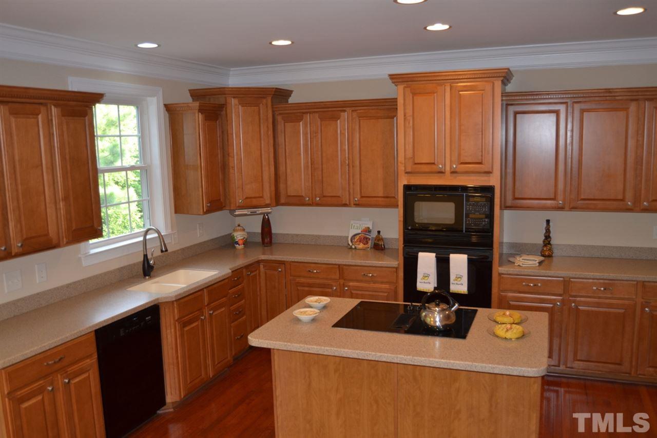 8425 Henderson Road Apex, NC 27539 - Photo 6 of 25 a kitchen with stainless steel appliances granite countertop a sink stove and cabinets