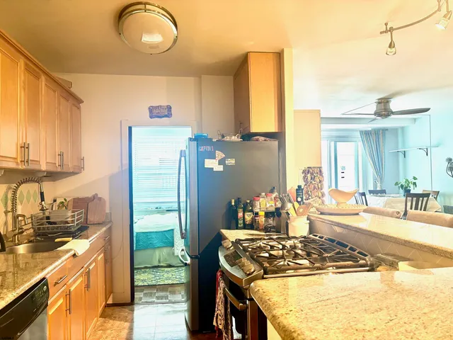 a kitchen with stainless steel appliances granite countertop a stove a sink and a refrigerator