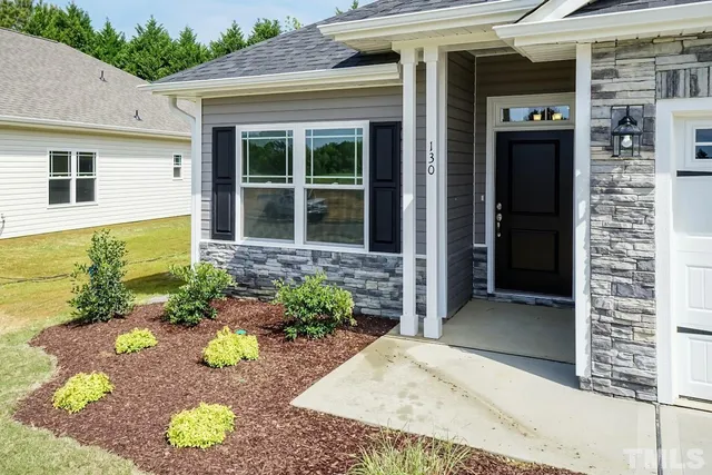 a view of a hallway with wooden floor and a bathroom