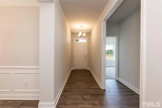 a view of an empty room with wooden floor fireplace and a window