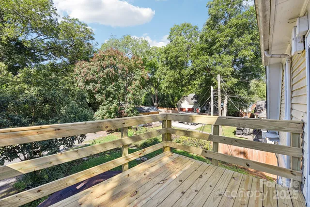 a view of a balcony with wooden floor and fence