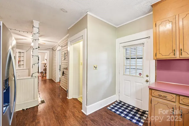 a view of a kitchen with a refrigerator wooden floor and a cabinet