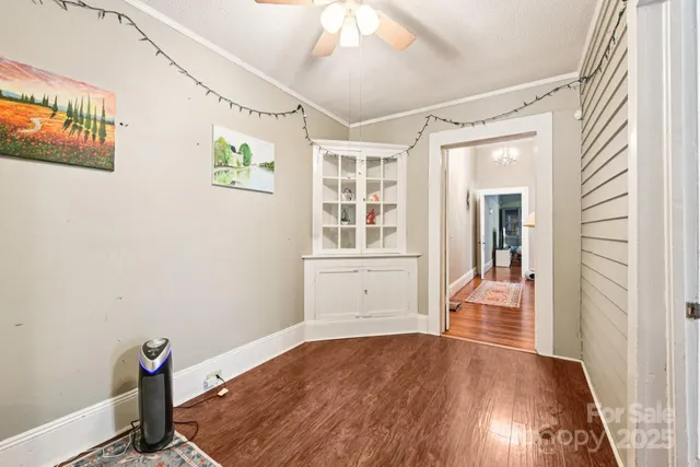 a view of a livingroom with wooden floor and a ceiling fan