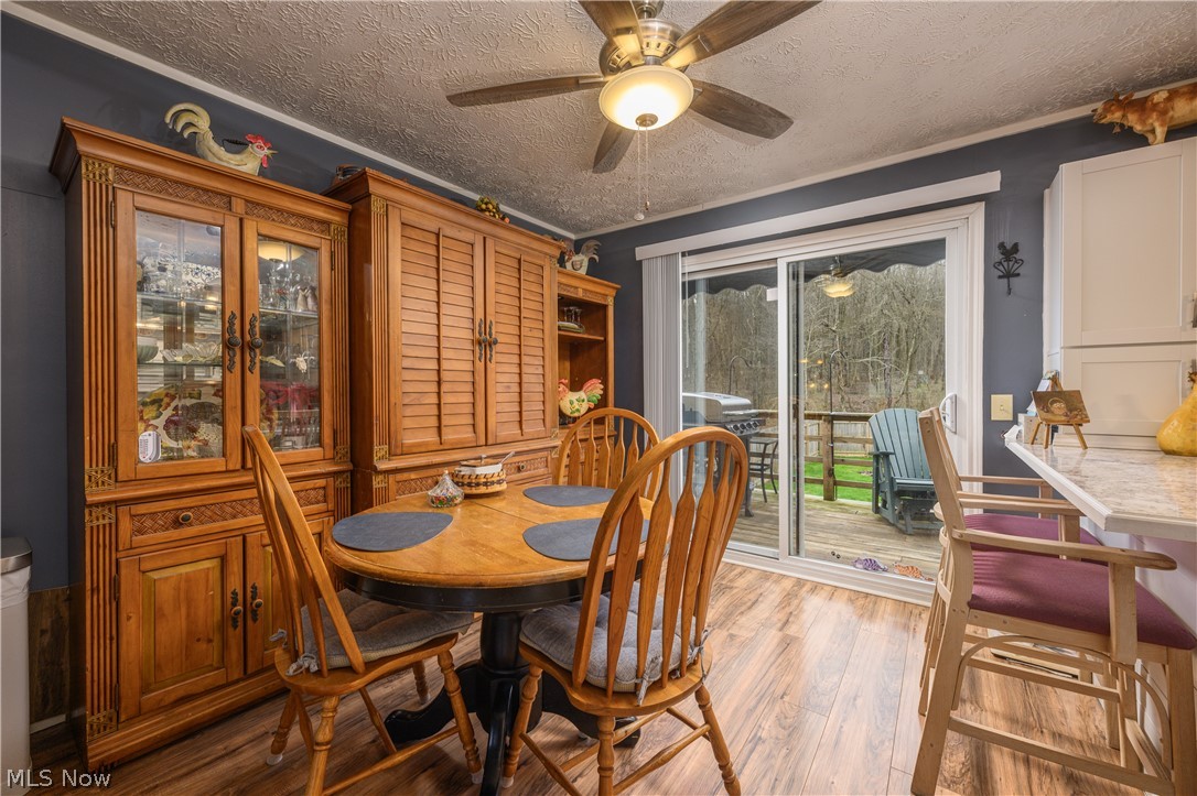 390 Ross Road Waynesburg, OH 44688 - Photo 7 of 30 Dining room with light wood-style floors, a ceiling fan, and a textured ceiling