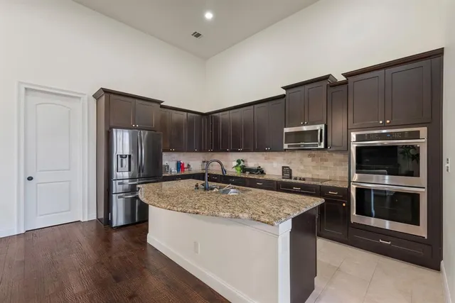 a kitchen with stainless steel appliances granite countertop a stove a refrigerator and a sink