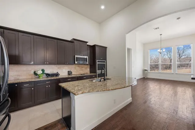 a kitchen with granite countertop a stove a sink and a microwave