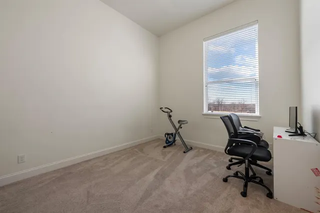 a view of a workspace with furniture and a window