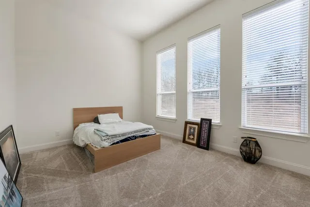 a bedroom with a bed and a couch next to a window