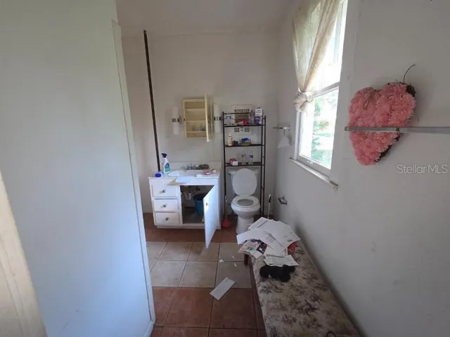 a bathroom with a sink toilet and window