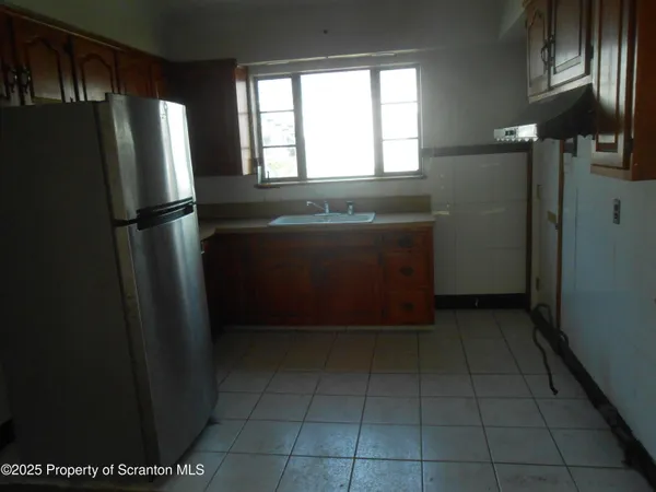 a view of a refrigerator in kitchen and window