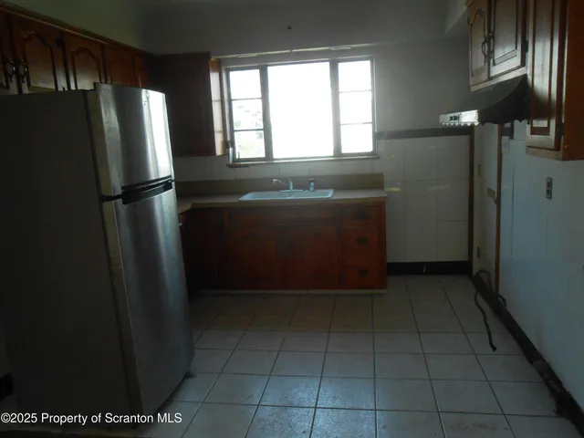 a view of a refrigerator in kitchen and window