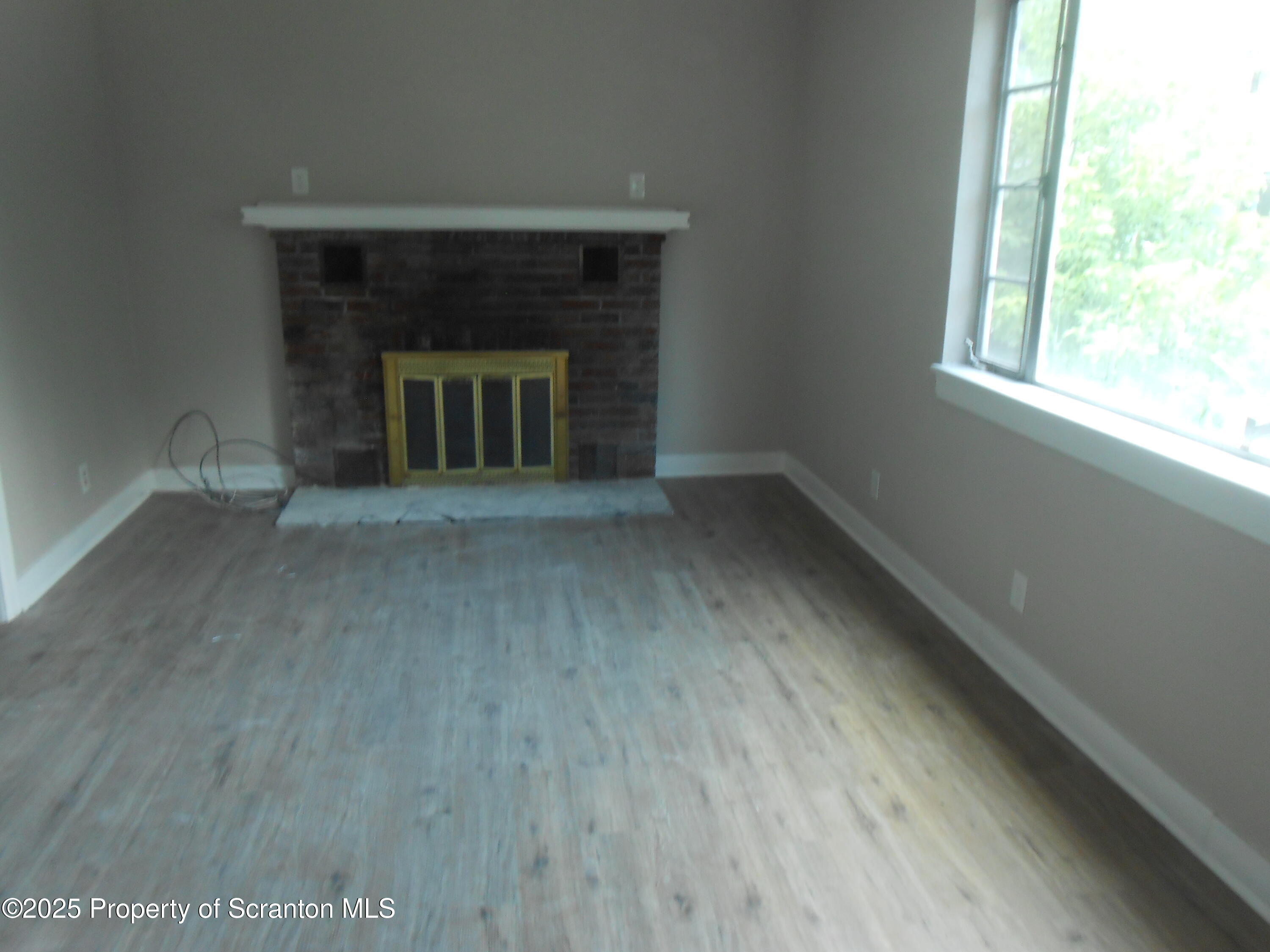 622 North Main Avenue, Unit 7 Scranton, PA 18504 - Photo 7 of 14 an empty room with wooden floor fireplace and windows