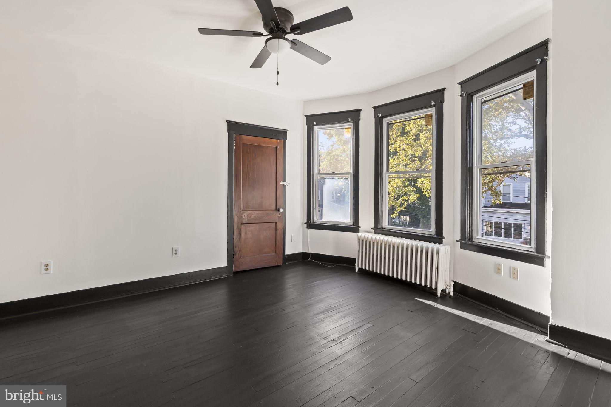 724 Ash Avenue, Unit 2 Collingdale, PA 19023 - Photo 11 of 17 an empty room with wooden floor and windows