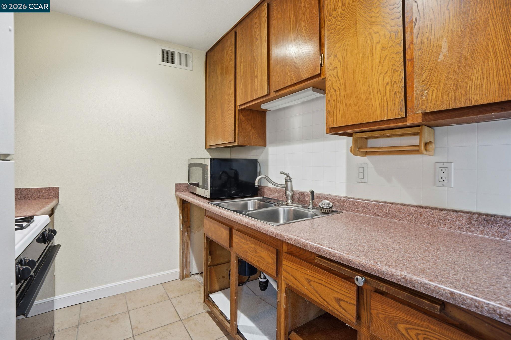 1160 Kenwal Road, Unit D Concord, CA 94521 - Photo 12 of 38 a kitchen with stainless steel appliances granite countertop a sink and a cabinets