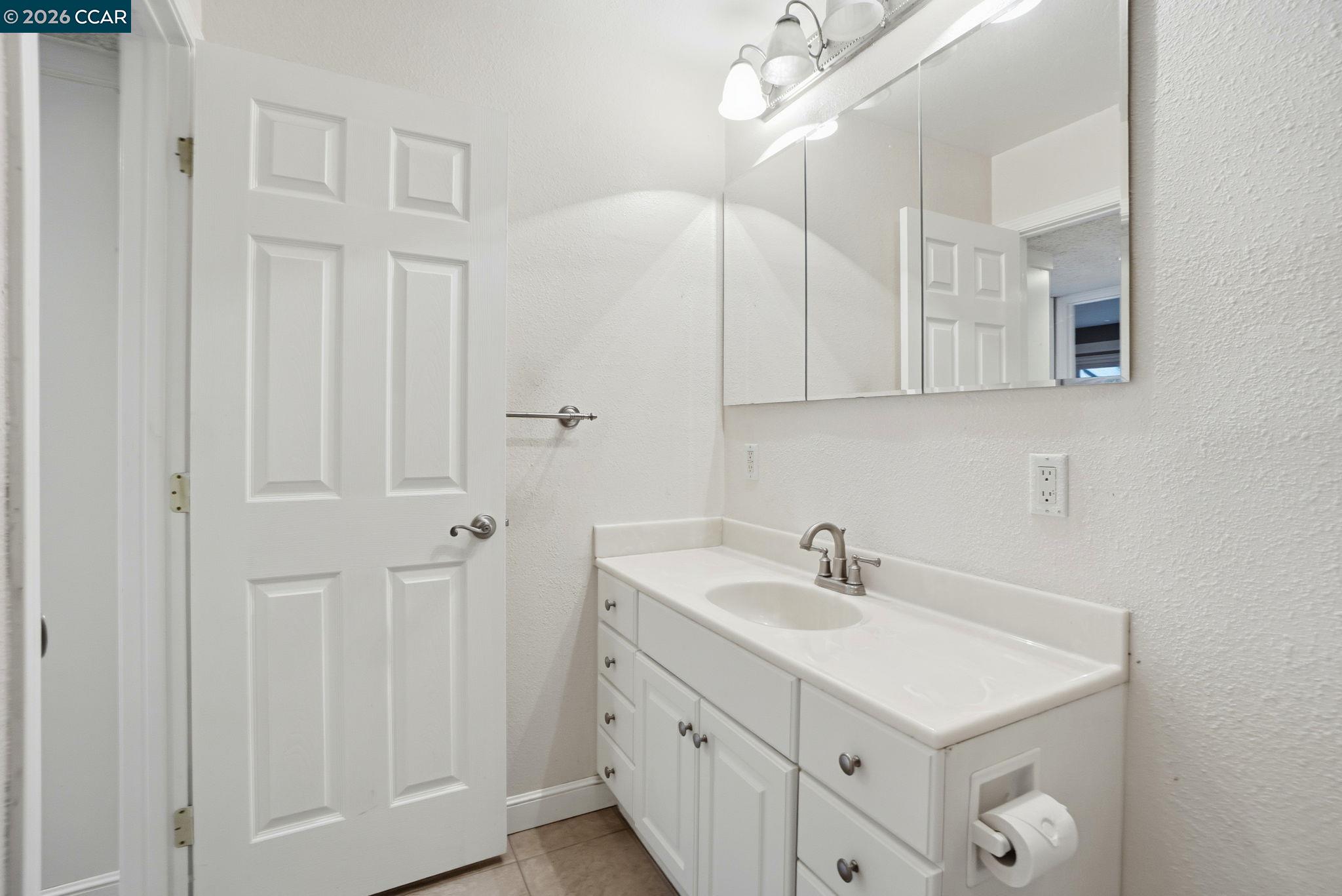 1160 Kenwal Road, Unit D Concord, CA 94521 - Photo 26 of 38 a bathroom with a sink a mirror and vanity