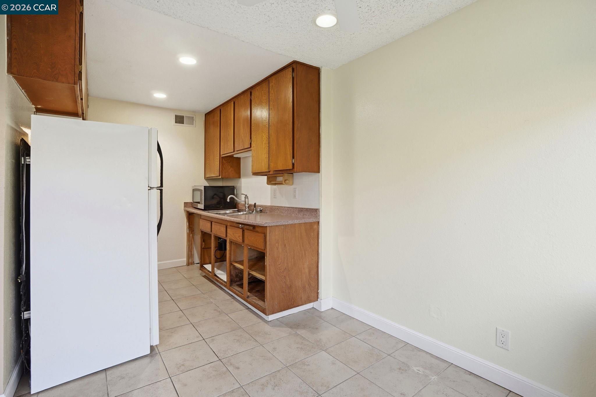 1160 Kenwal Road, Unit D Concord, CA 94521 - Photo 9 of 38 a kitchen with stainless steel appliances a refrigerator and a stove