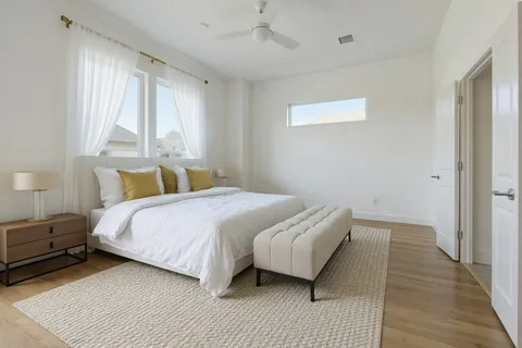 a bedroom with a bed a painting and a window