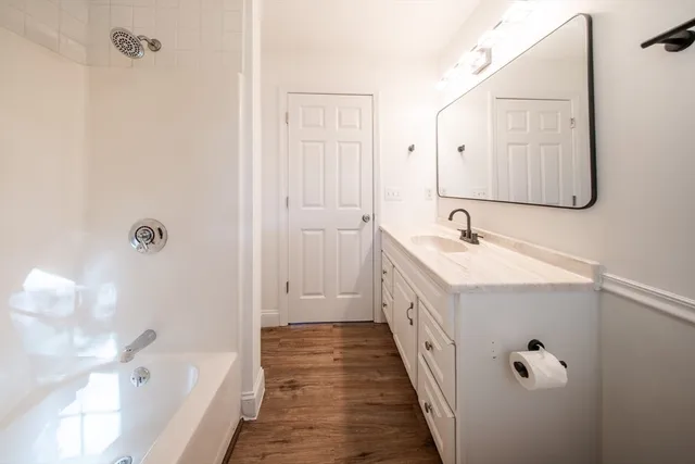 a bathroom with a double vanity sink a mirror and a bathtub