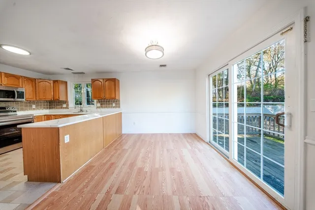 a large kitchen with kitchen island wooden floors and stainless steel appliances