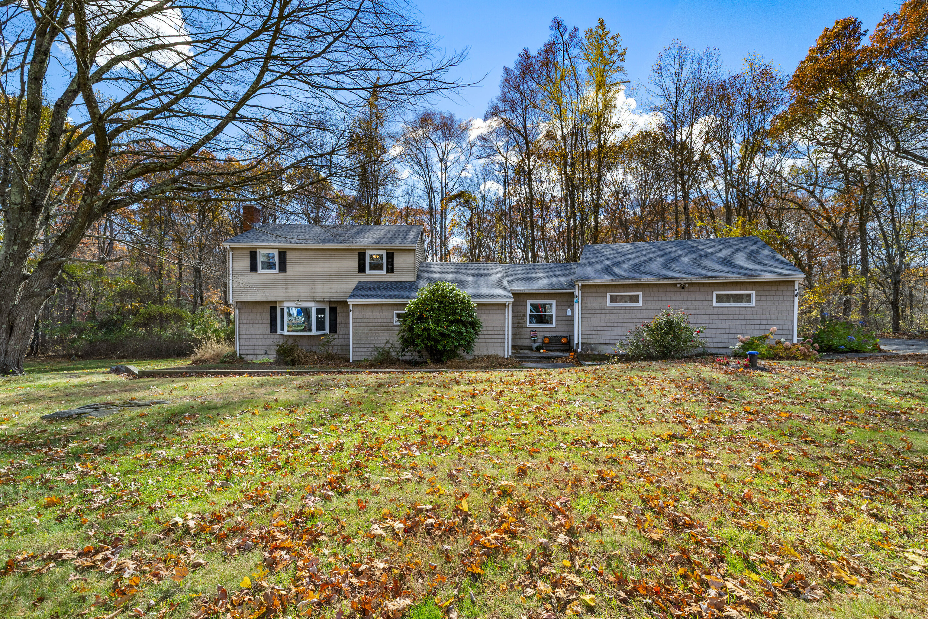 a front view of a house with a yard and trees