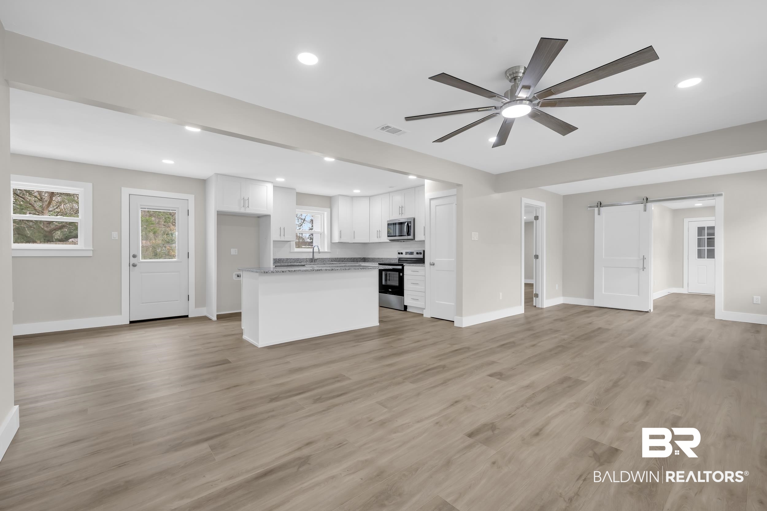 11381 Normandy Drive East Semmes, AL 36575 - Photo 4 of 23 Unfurnished living room featuring a barn door, ceiling fan, recessed lighting, and light wood finished floors