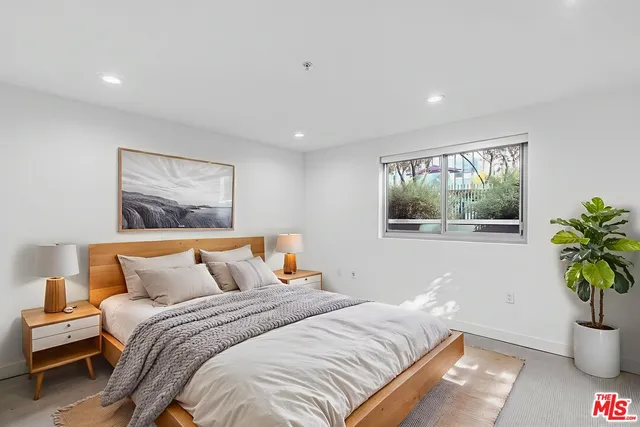a bedroom with a bed and a potted plant