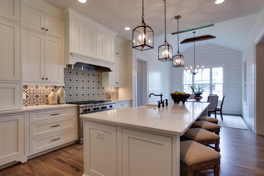 112 Alton Road Nashville, TN 37205 - Photo 12 of 30 a kitchen with stainless steel appliances granite countertop a stove a refrigerator a sink a dining table and chairs with wooden floor