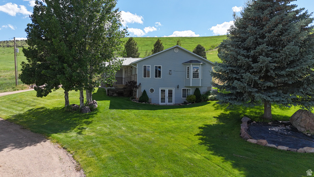 9029 North Treasureton Road Preston, ID 83263 - Photo 27 of 31 Light blue siding exterior featuring a metal roof, bay window, and lower-level French doors