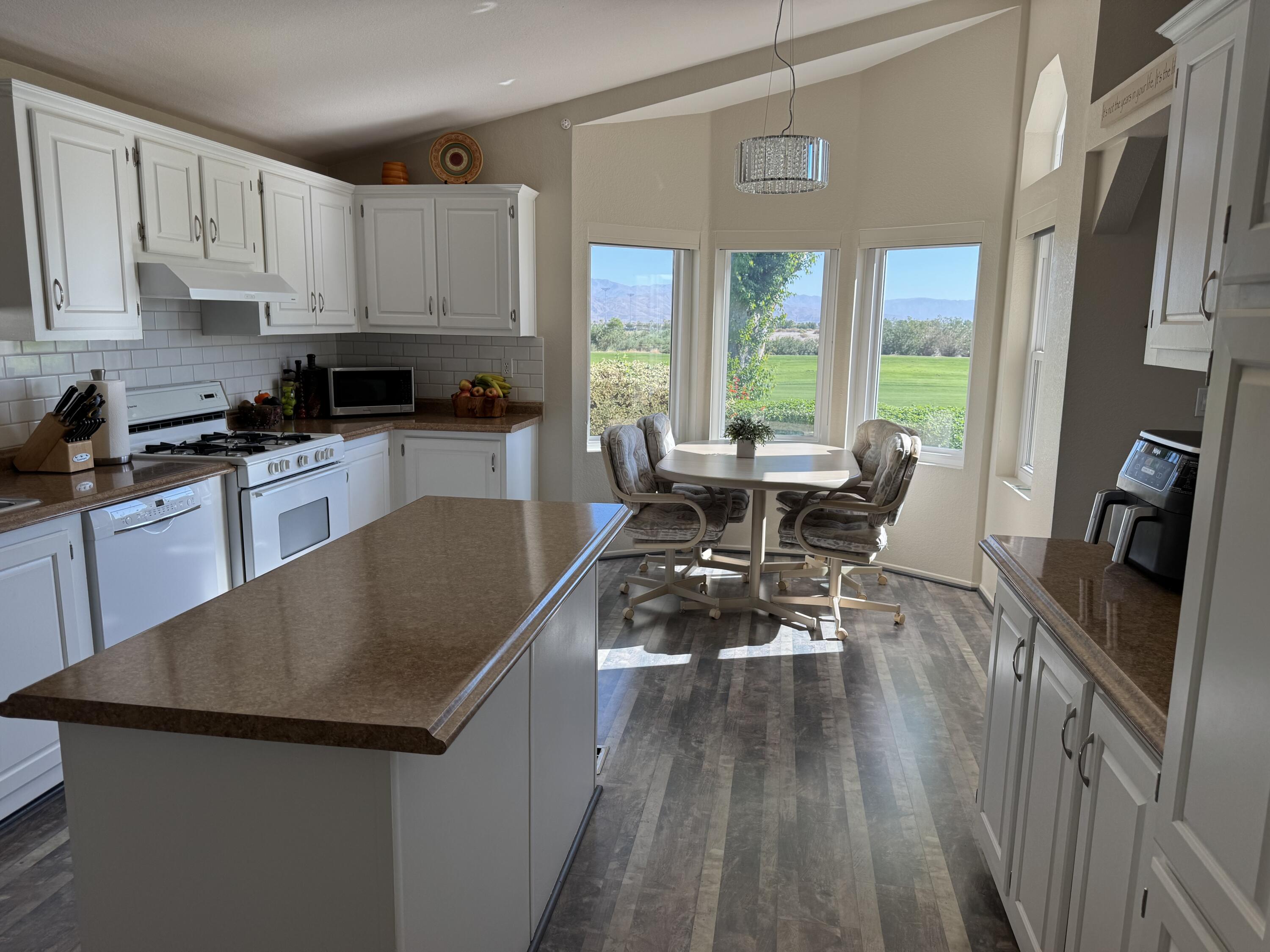 35280 South Border Thousand Palms, CA 92276 - Photo 23 of 50 a kitchen with a table chairs refrigerator and cabinets