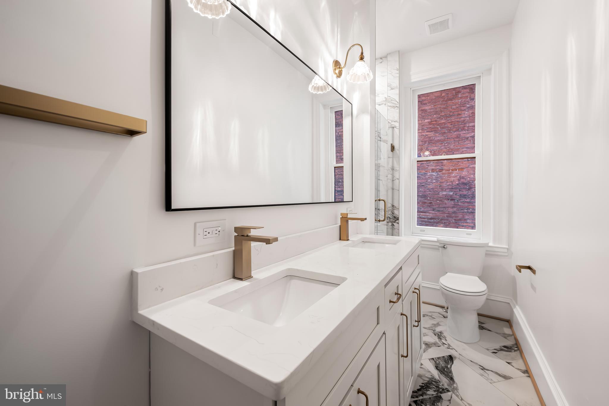 1202 Bolton Street, Unit 1 Baltimore, MD 21217 - Photo 12 of 22 a bathroom with a sink a toilet and a mirror
