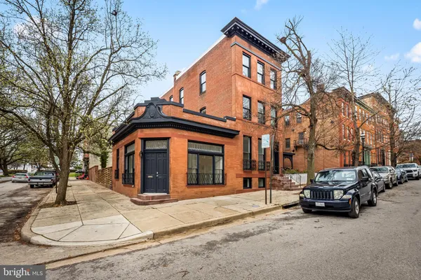 a front view of a building with cars parked