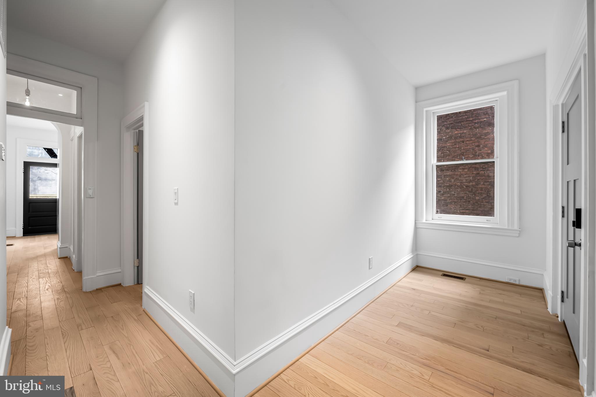 1202 Bolton Street, Unit 1 Baltimore, MD 21217 - Photo 9 of 22 wooden floor in an empty room with a window