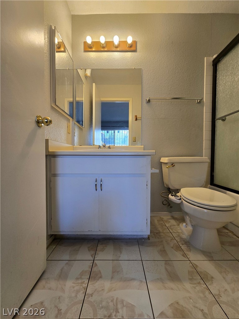 6750 Del Rey Avenue, Unit 133 Las Vegas, NV 89146 - Photo 20 of 34 Functional bathroom features a bright vanity area, toilet, and tiled flooring.