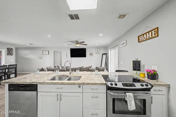 a kitchen with a sink and a stove top oven with wooden floor